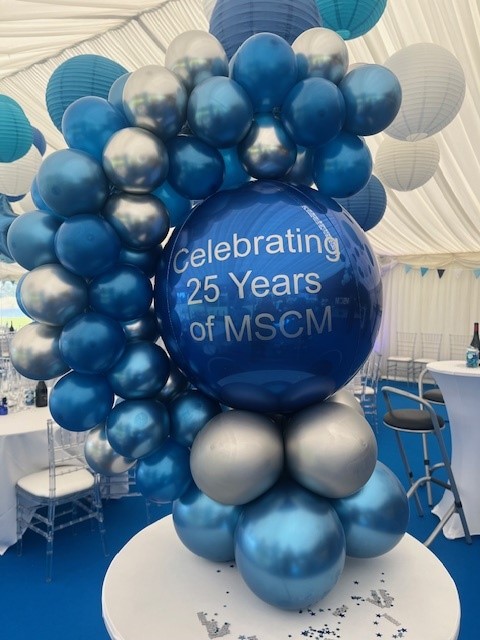 Blue and silver balloon display reading 'Celebrating 25 Years of MSCM'